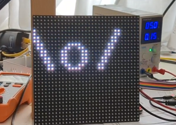 One 32x32 rgb led panel showing \o/ white on black