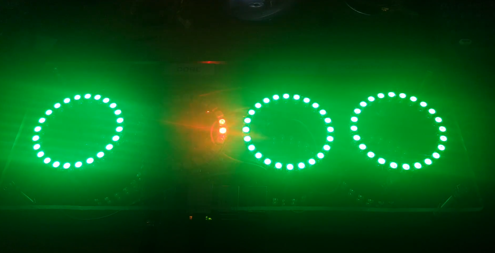 Four 24 rgb led rings, three all green and one with two red leds lit.